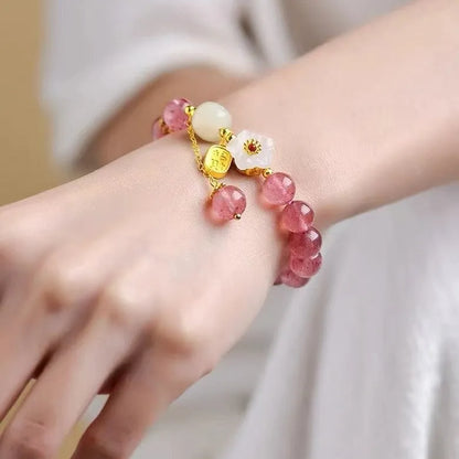 Handcrafted strawberry quartz crystal bracelet with adjustable string closure and Hetian jade peach blossom design