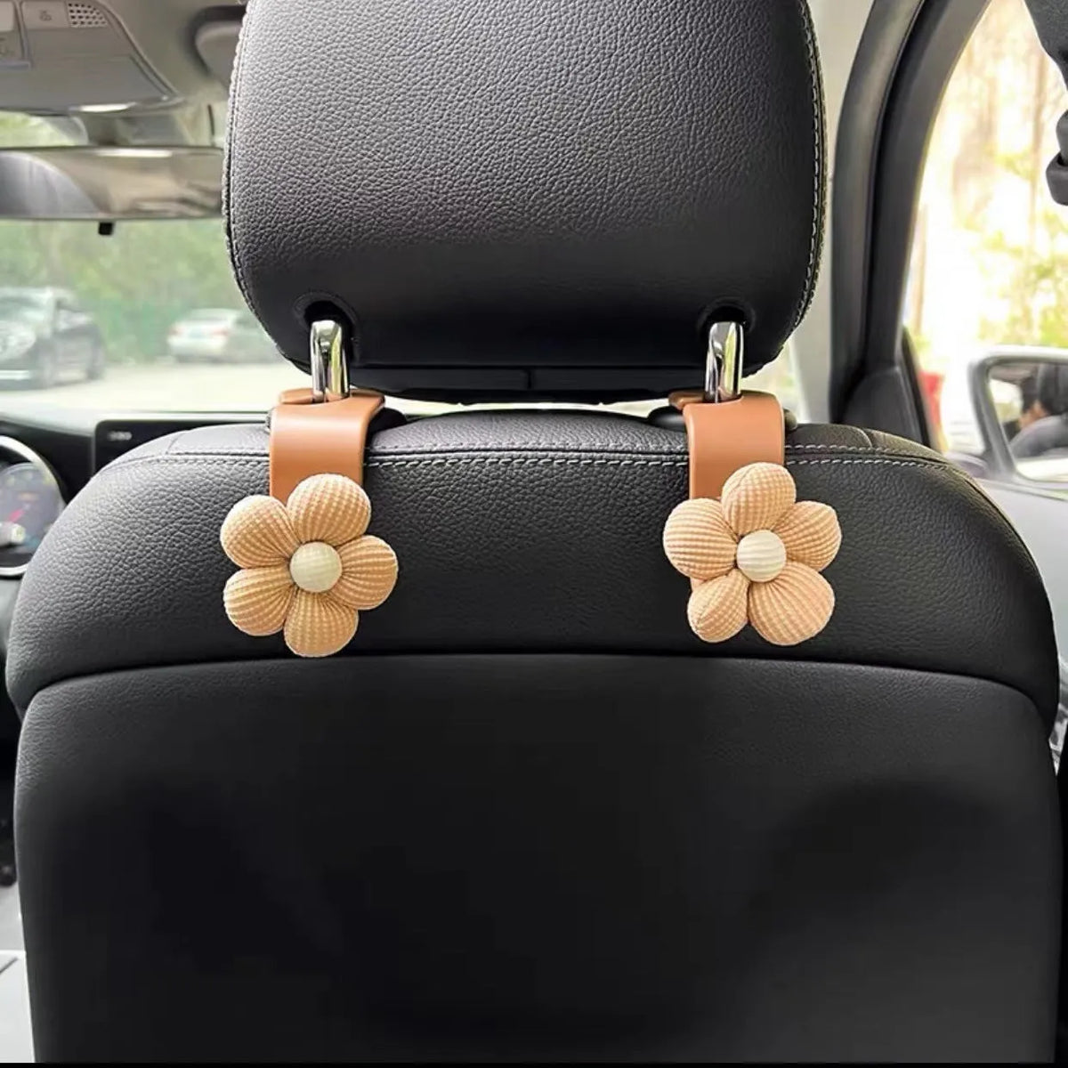Khaki coloured plastic car seat hook with floral pattern for storage, shown at 11 by 5.5 cm.