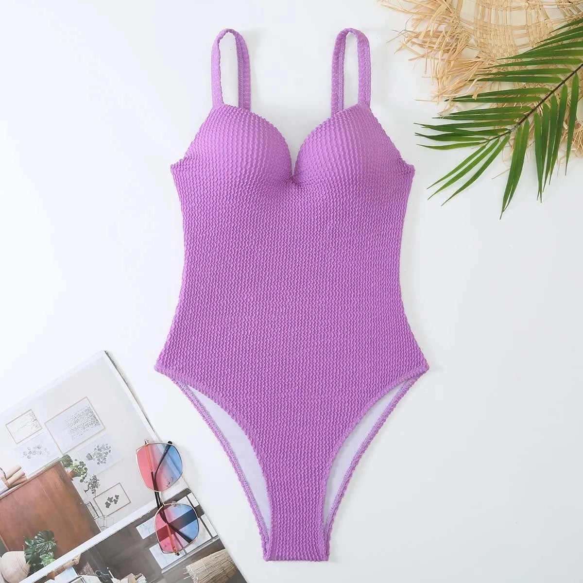 Women's black one-piece swimsuit with a sunken vertical stripe detail, shown on a model, featuring a sleeveless design.