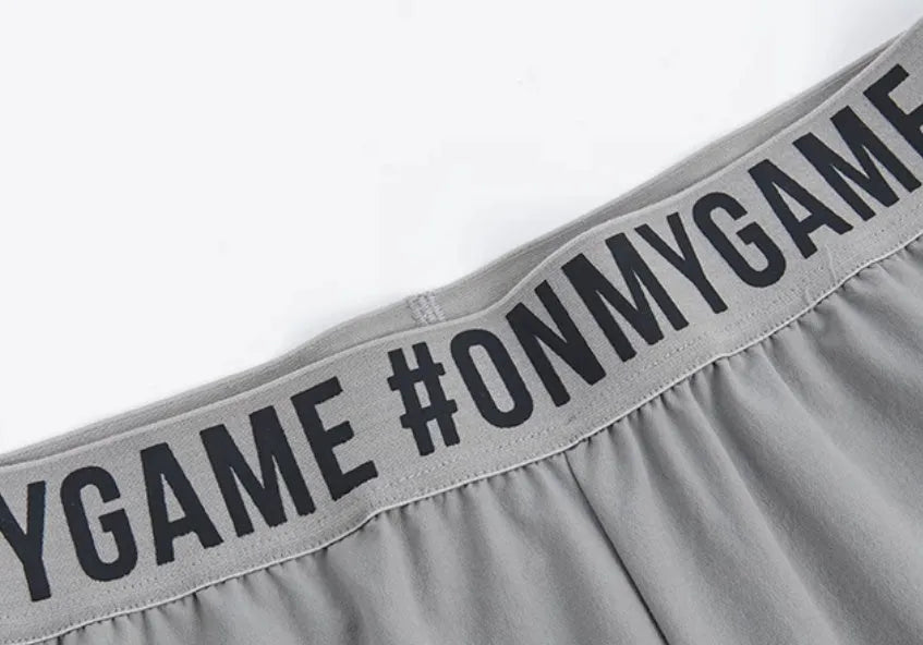 Women's loose sports cropped pants in grey with printed waistband for workouts and running activities
