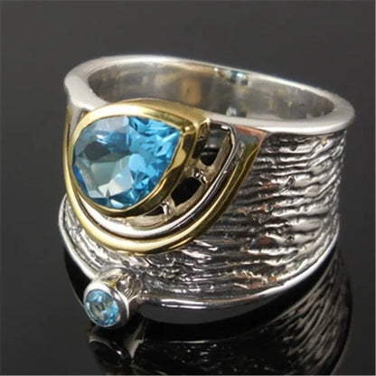 Blue drop-shaped zircon stone set in a Chinese-inspired alloy ring on a model's hand.