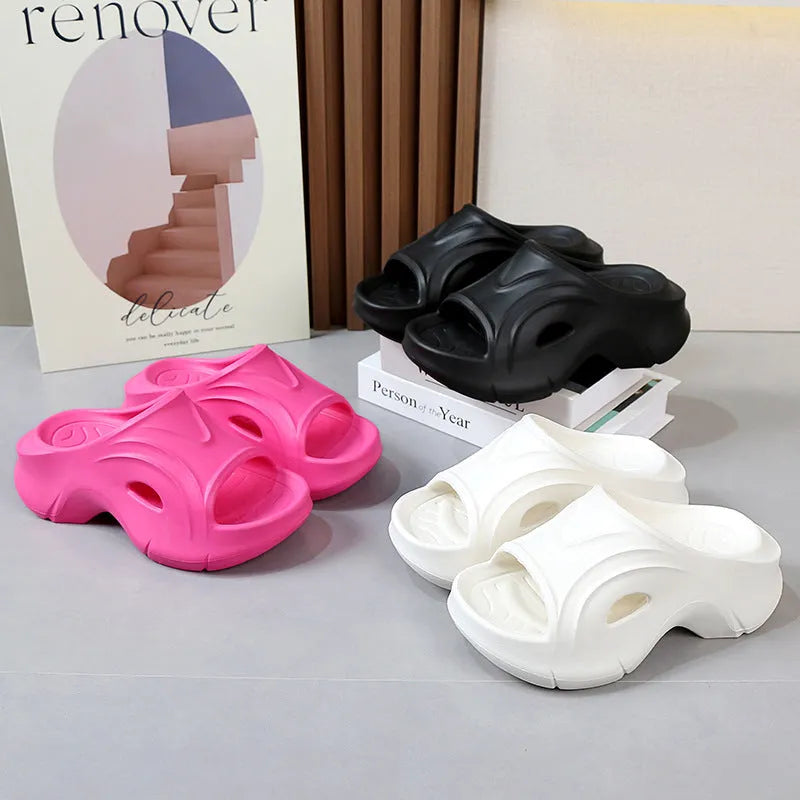 Women's thick-soled EVA foam beach slippers in rose red colour on a sandy background.