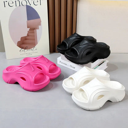 Women's thick-soled EVA foam beach slippers in rose red colour on a sandy background.