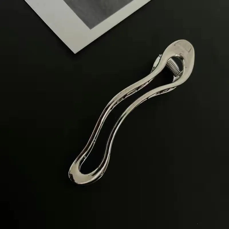 Women's gold and silver zinc alloy hair barrettes in arc, square, and triangle shapes.