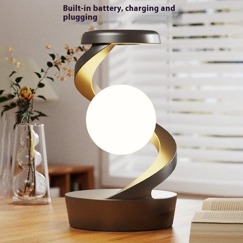 A rotating moon-shaped desk lamp with a wireless charging pad for smartphones, featuring a sleek and modern design.