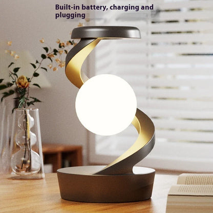 A rotating moon-shaped desk lamp with a wireless charging pad for smartphones, featuring a sleek and modern design.