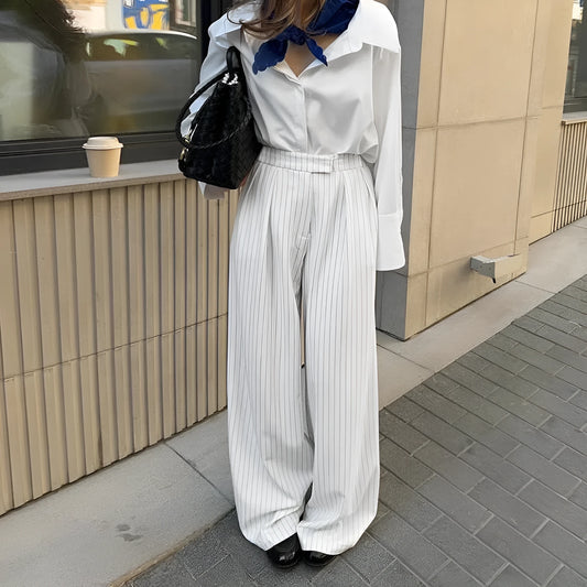 White striped wide-leg casual trousers with a front zipper on a hanger.