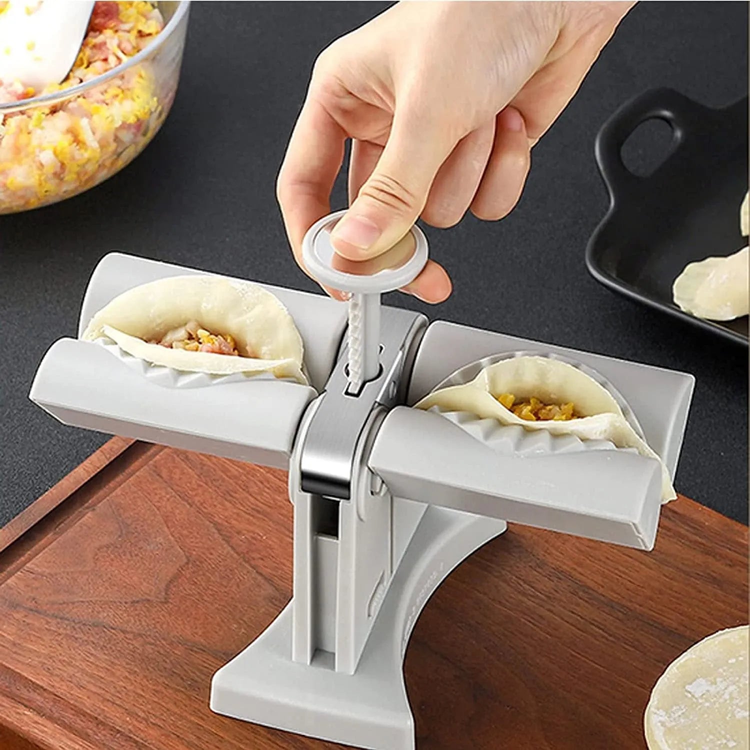 White double-head manual dumpling maker press on a kitchen counter