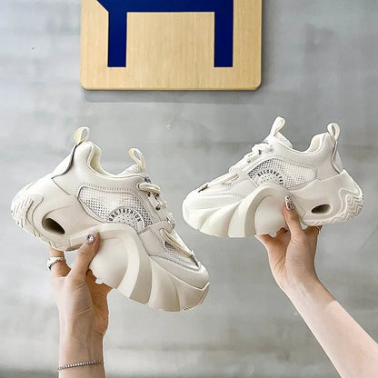 Women's pink sneakers with cross straps, thick sole, and mesh lining on a white background