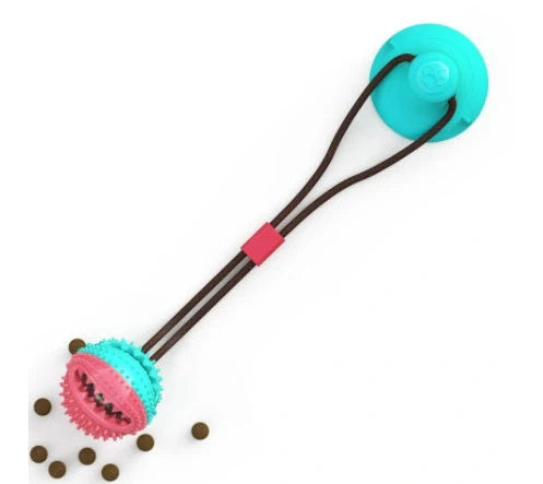 Red and blue silicone dog ball toy with suction cup attached to tile surface