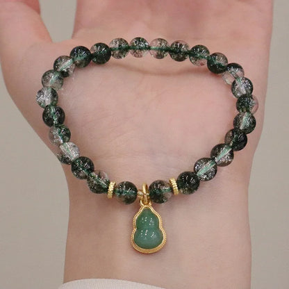 Women's bracelet with citrine, chorite, and a green phantom quartz heart charm.