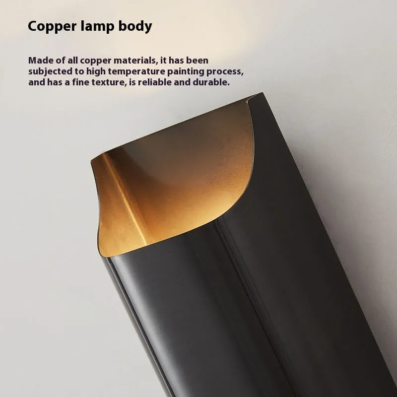 Minimalist copper wall lamp in black gold finish mounted beside bed