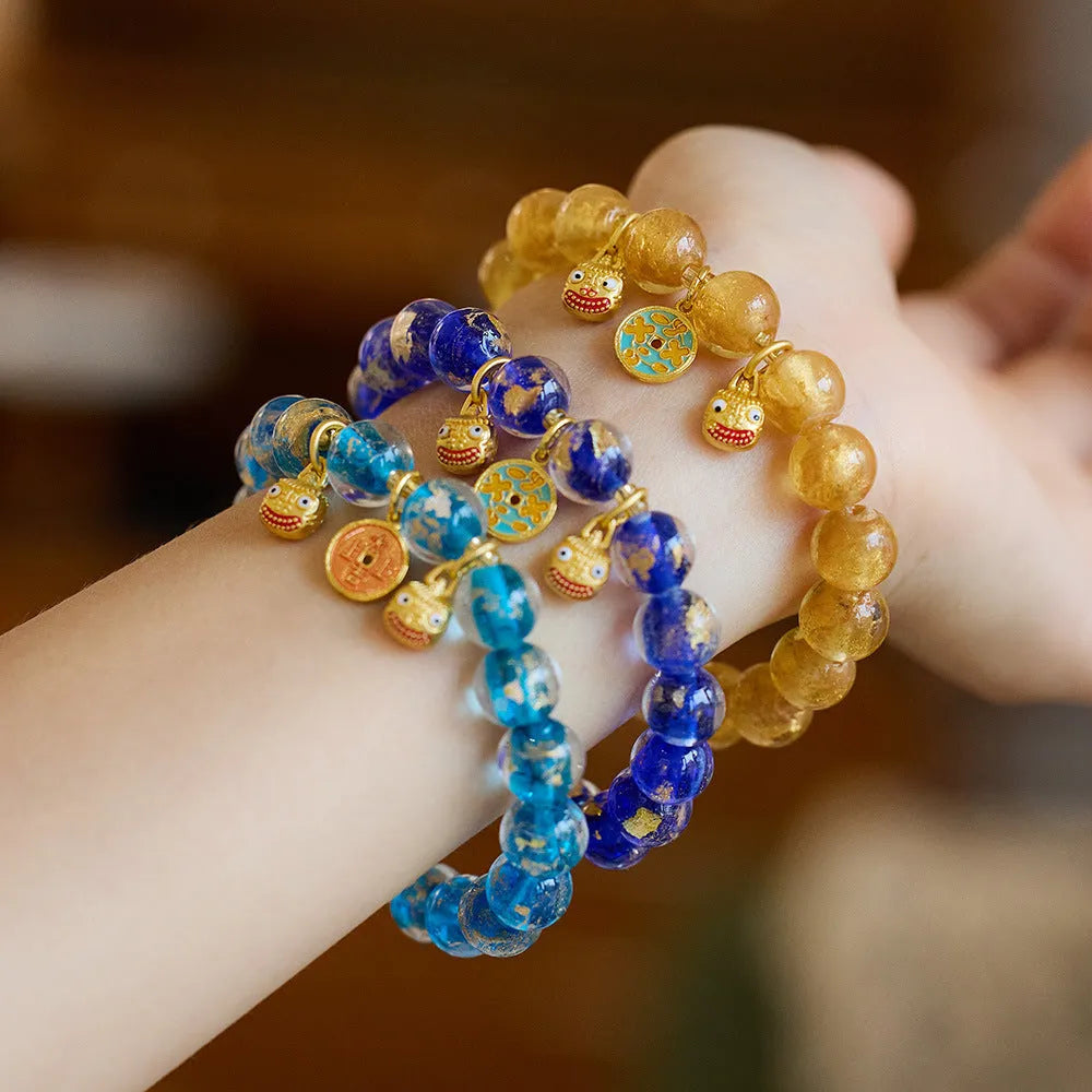 Handmade national style bracelet with coloured glaze swallowing gold beast charm on beaded band.