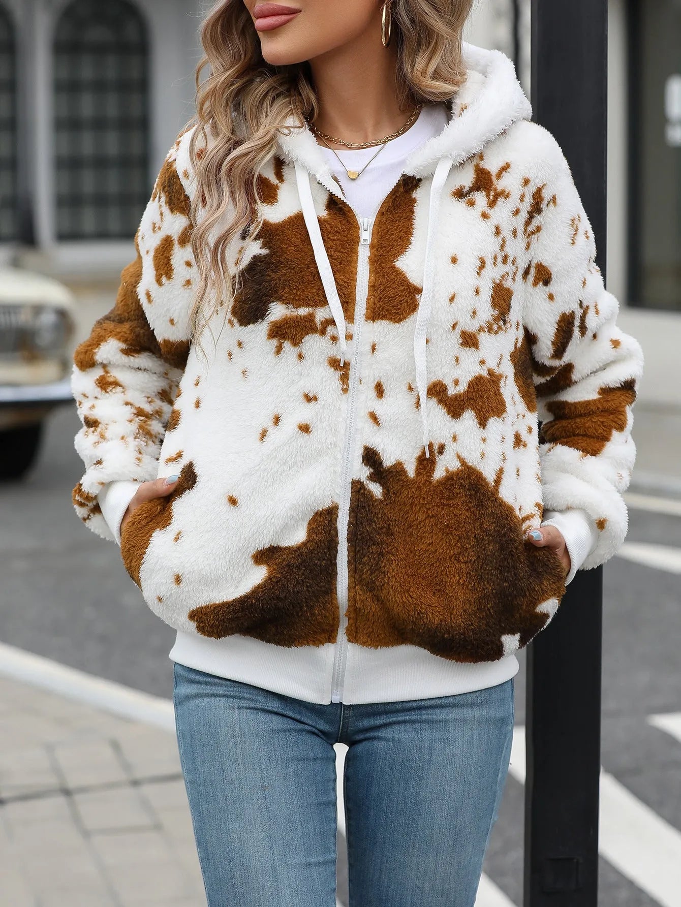 Yellow-brown cow print hooded cardigan jacket with a full-length zip front on a model.