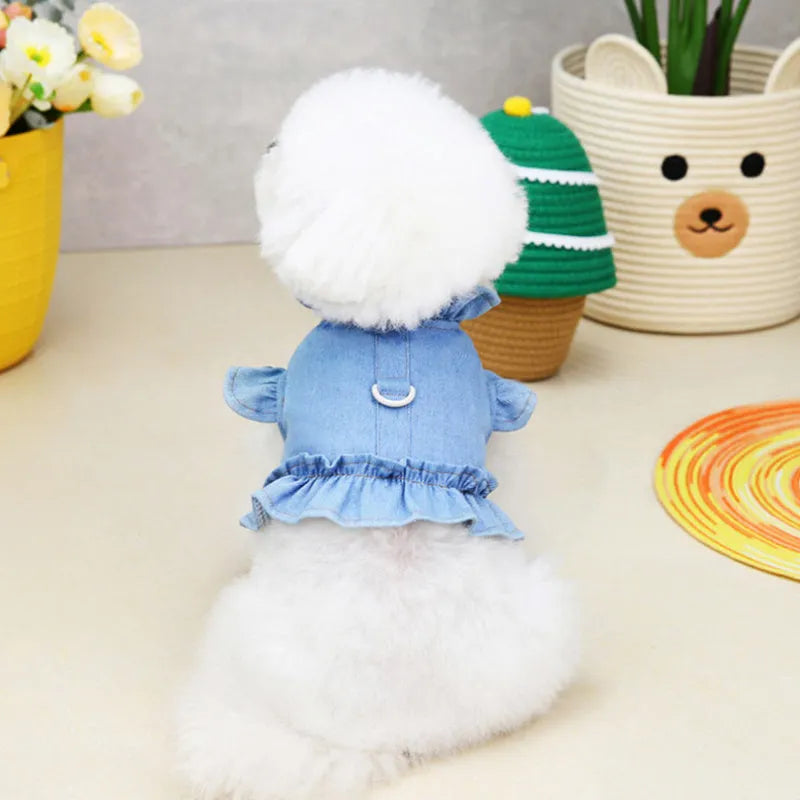 Blue denim dog dress with ruffles and integrated harness for leash attachment.