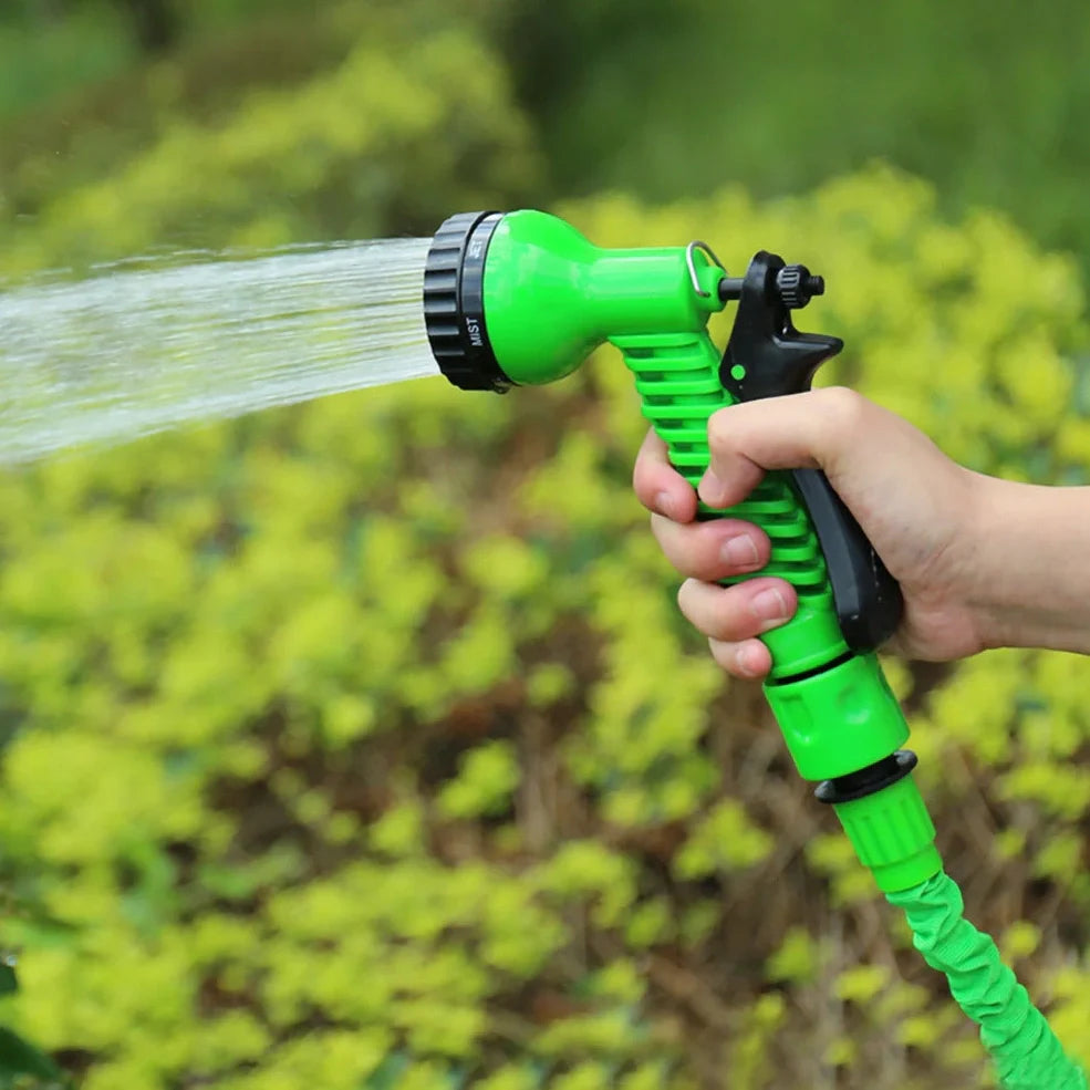 Blue telescopic water hose with high-pressure gun, expanded for use in garden watering
