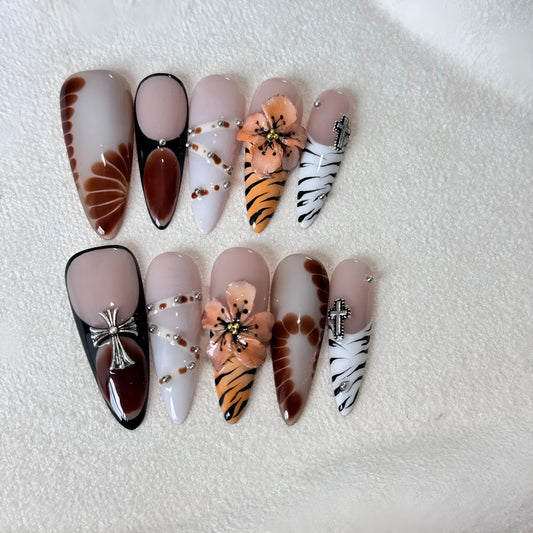 Set of ten leopard print, cross, and floral design press-on nail stickers in long-tip style on a white background.