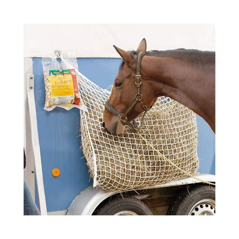 Black woven grid hanging feeding bag for horses, shown against a stable background.