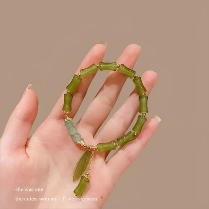 Chinese style glass bead bracelet with bamboo joint design on wrist.