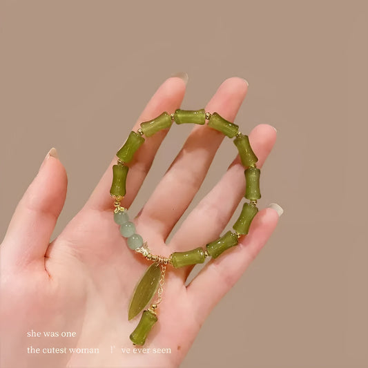 Chinese style glass bead bracelet with bamboo joint design on wrist.