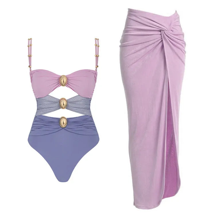 A woman's solid-colour one-piece swimsuit with a gold button detail and an attached matching skirt.