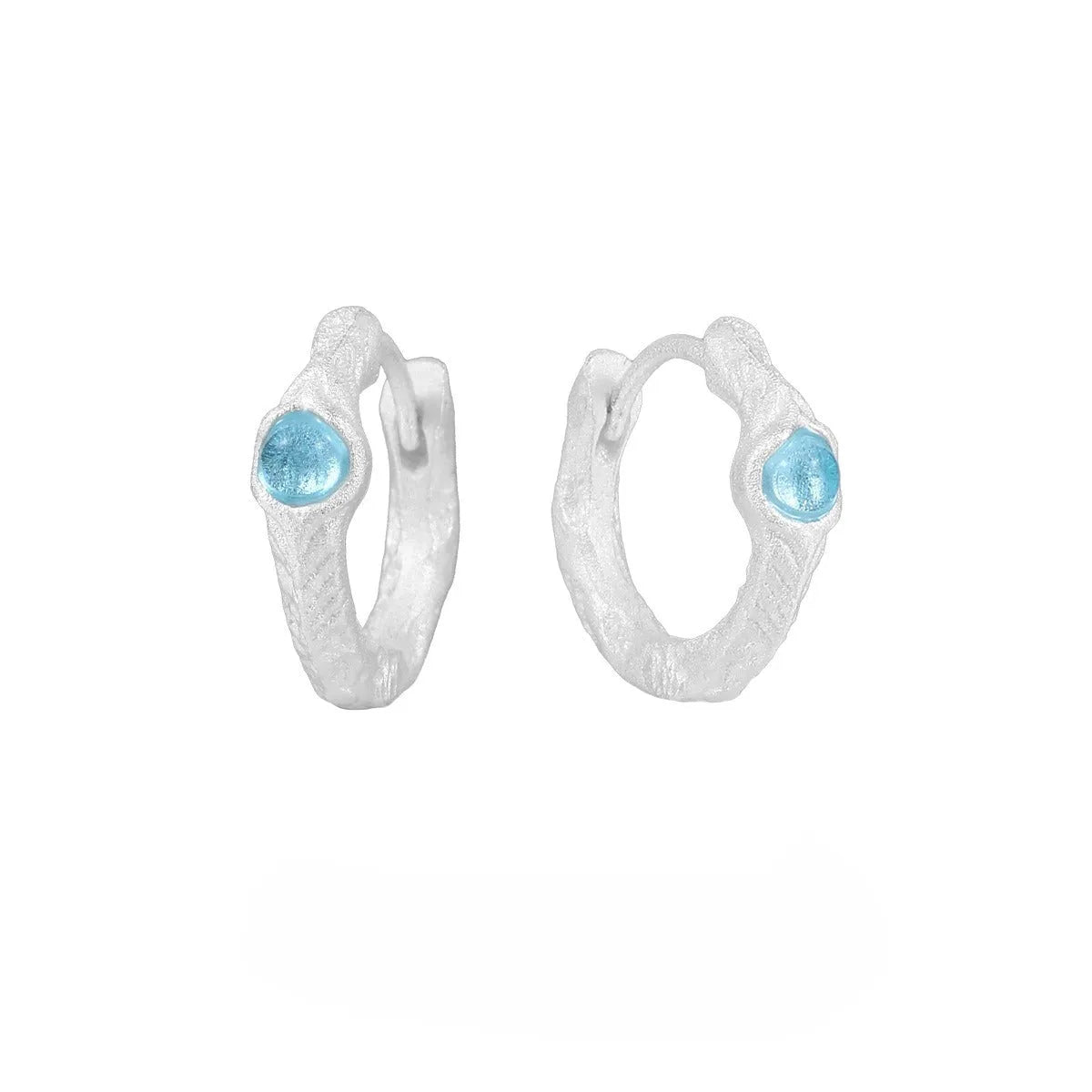 A pair of geometric round ear clips made from 925 silver with a burnt silver electroplated finish.