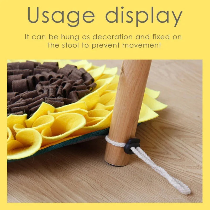 Yellow sunflower-shaped dog snuffle mat for slow feeding and nosework training on a floor.