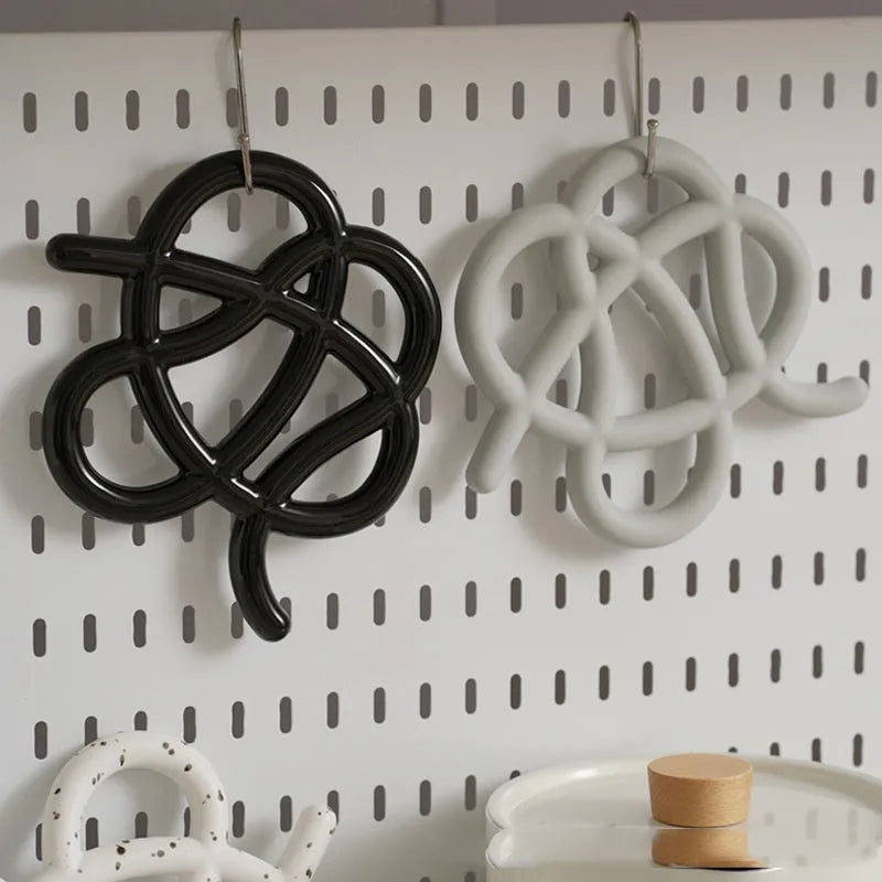 Ceramic heat-proof mat in irregular shape on dining table, protecting surface from hot pot