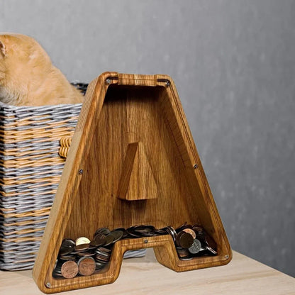 Handmade wooden letter piggy bank with personalised initial, showing 15cm height and 5cm coin slot for UK coins