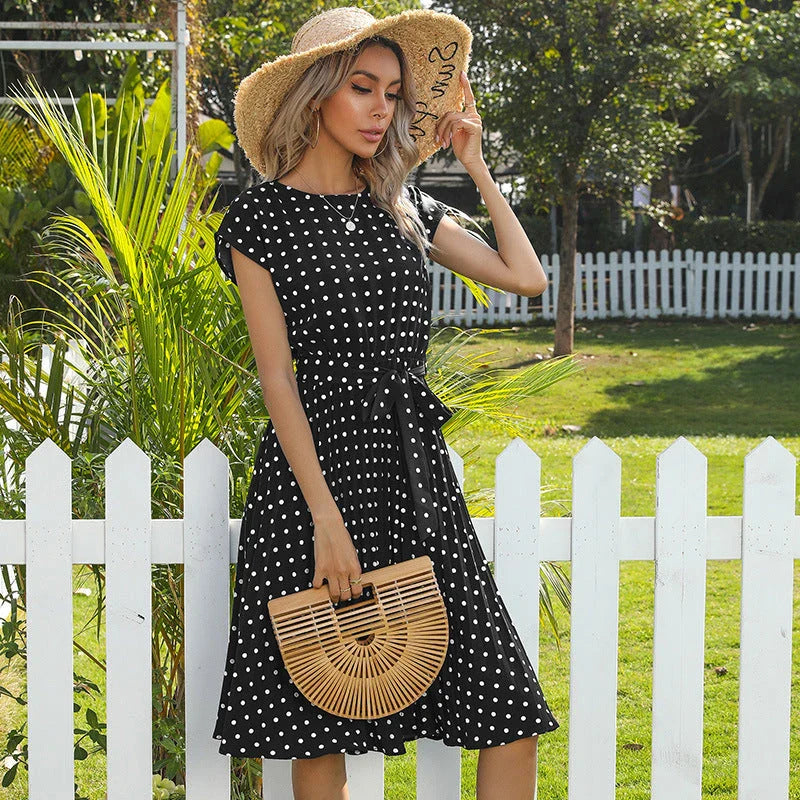 Elegant polka dot midi dress with short sleeves, made of soft viscose fabric and featuring a flattering pleated A-line skirt