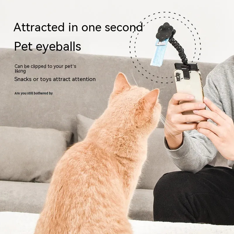 Black plastic pet photography tool attached to mobile phone with treat clip extended