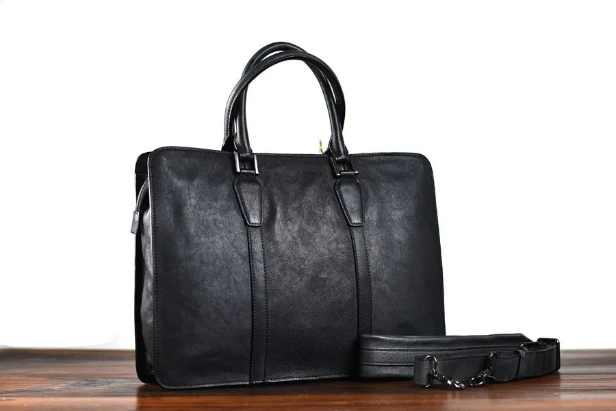 Khaki men's retro leather handbag with a horizontal square shape and top zipper, shown on a table.