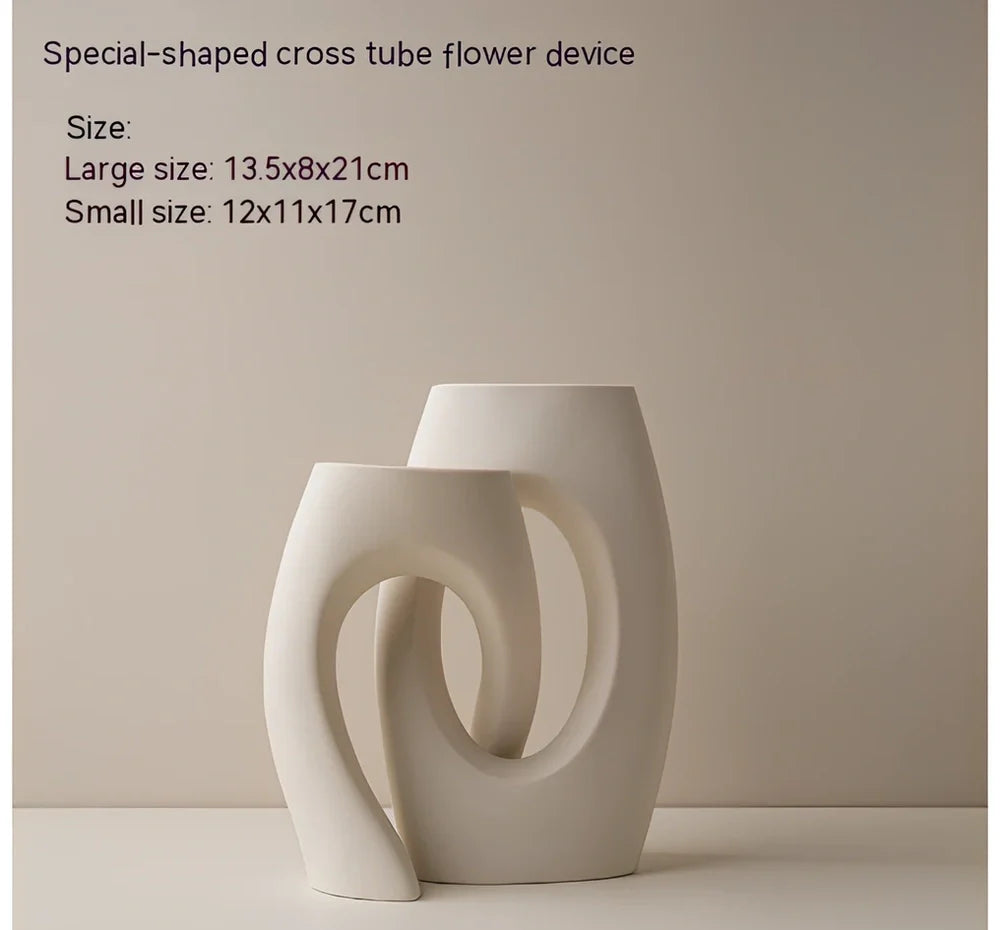 White ceramic circle vase with hand-painted coloured glaze on wooden table with dried flowers