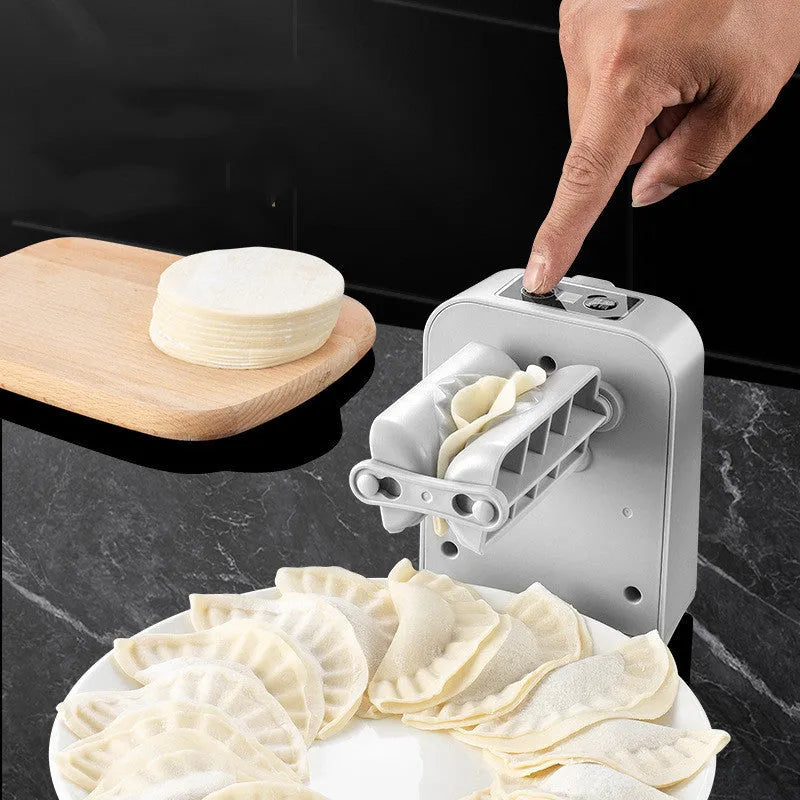 White automatic electric dumpling maker machine with USB cable, brush, and spoon.