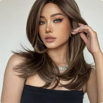Mid-length curly synthetic wig with long bangs in a platinum gradient colour, shown on a wig stand.