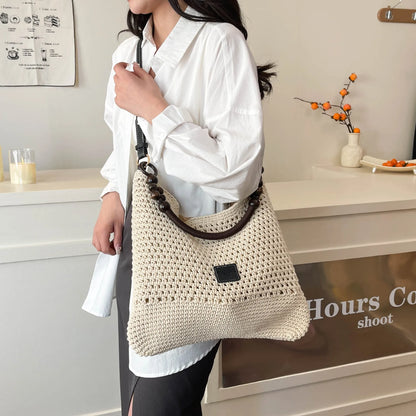 Large brown knitted bucket tote beach bag with contrast stitching and a zip internal compartment.