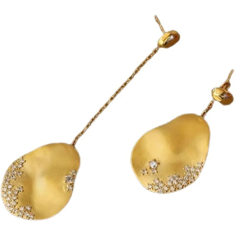 Asymmetric floral drop earrings with gold plating and zircon stone accents in silver colour