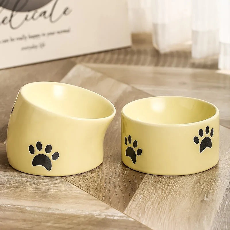 Ceramic cat bowl with high foot and cat's paw base in an oblique mouth design.