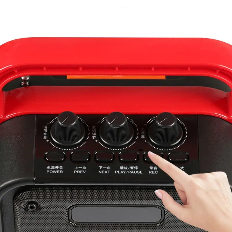 MS62AI portable Bluetooth speaker with wireless microphone on a table, showing control knobs and carrying strap.