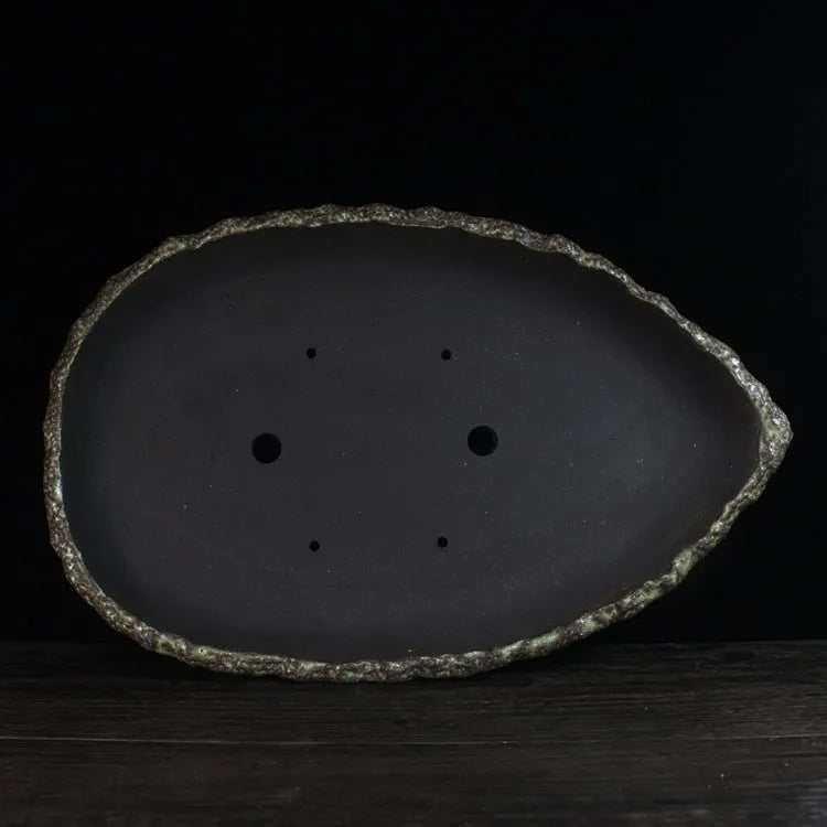 Handmade purple clay flower pot with unique shape showing natural ceramic texture