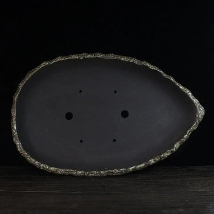 Handmade purple clay flower pot with unique shape showing natural ceramic texture