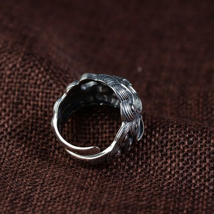 Silver open-style ring with a detailed raised jibeast animal pattern on a model's finger.