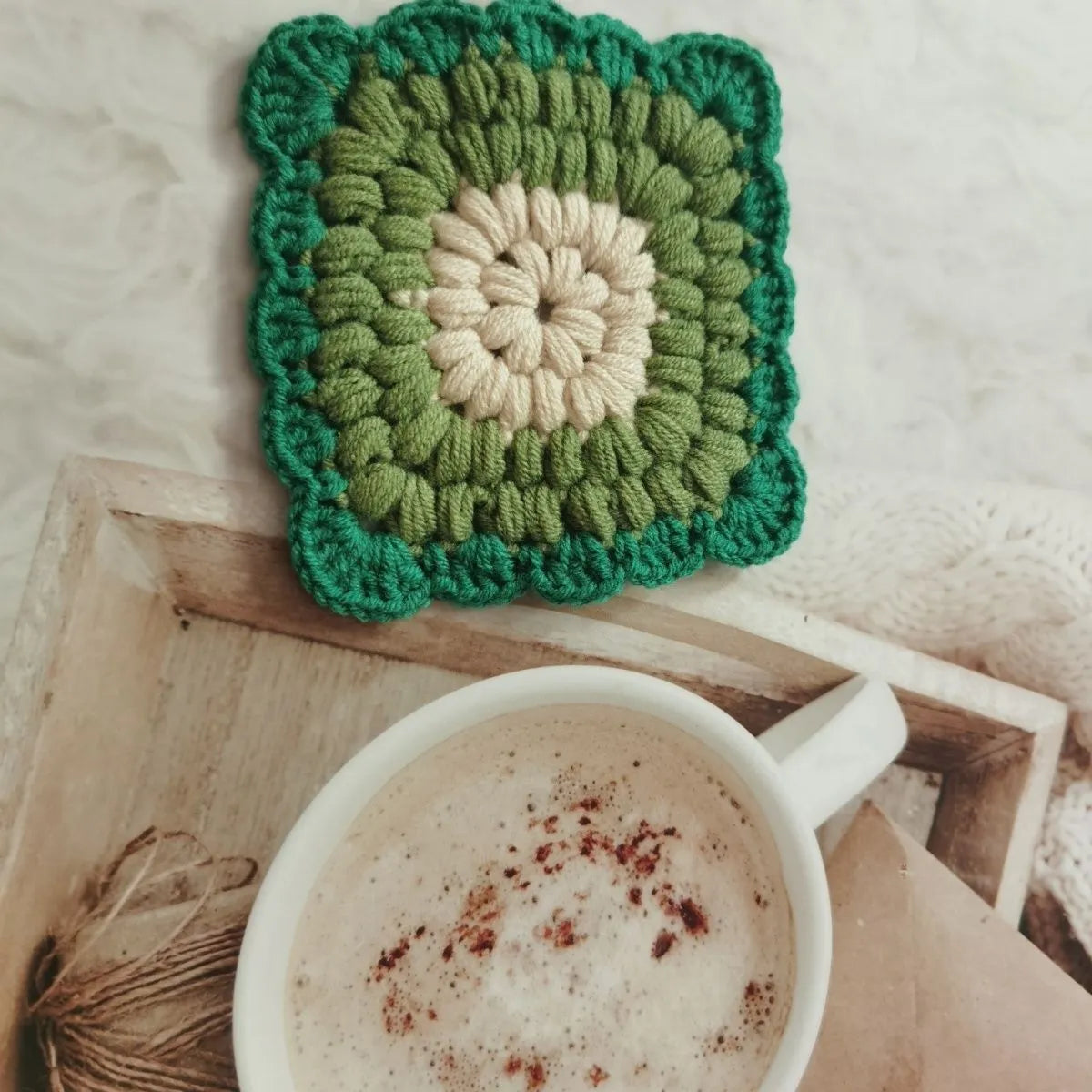 Crocheted wool cup coaster with grandmother lattice pattern in selected colour