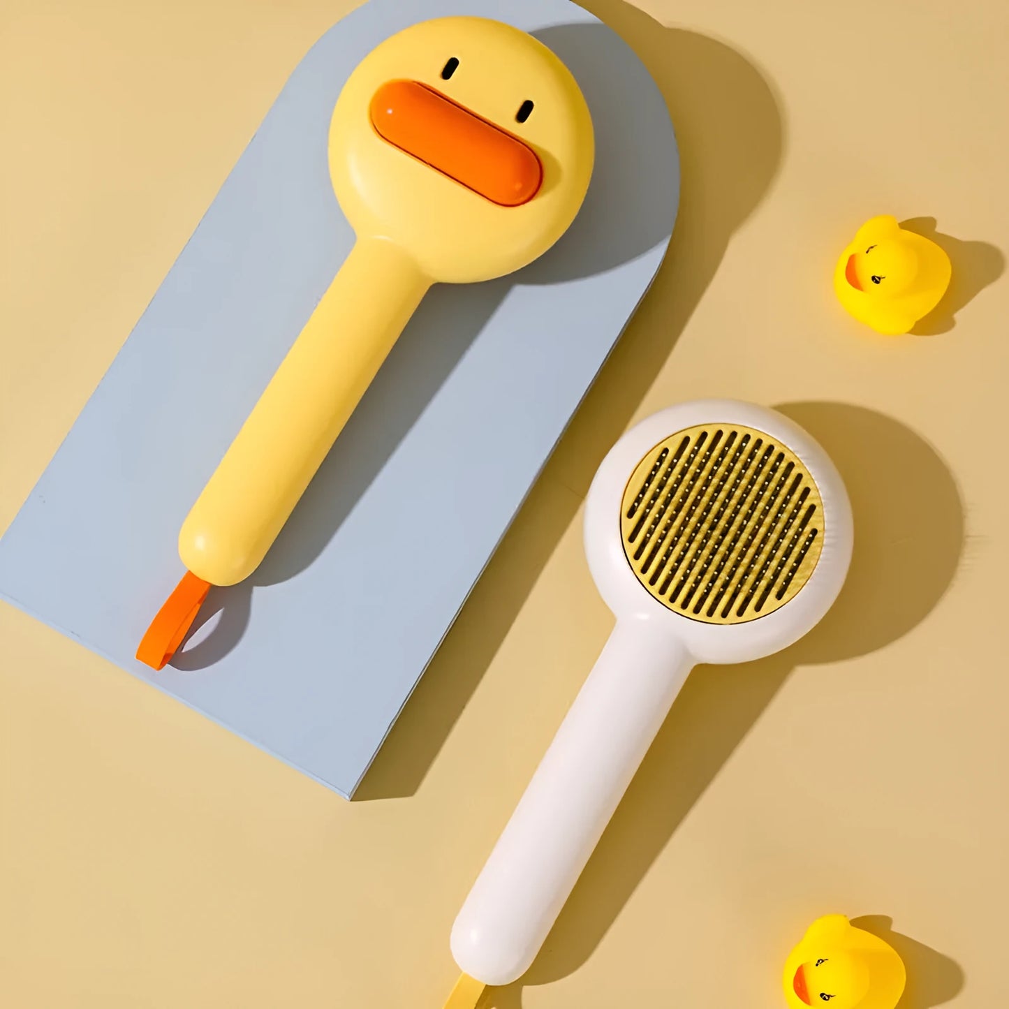 Small yellow duck-shaped pet grooming comb with needle pins and open section design