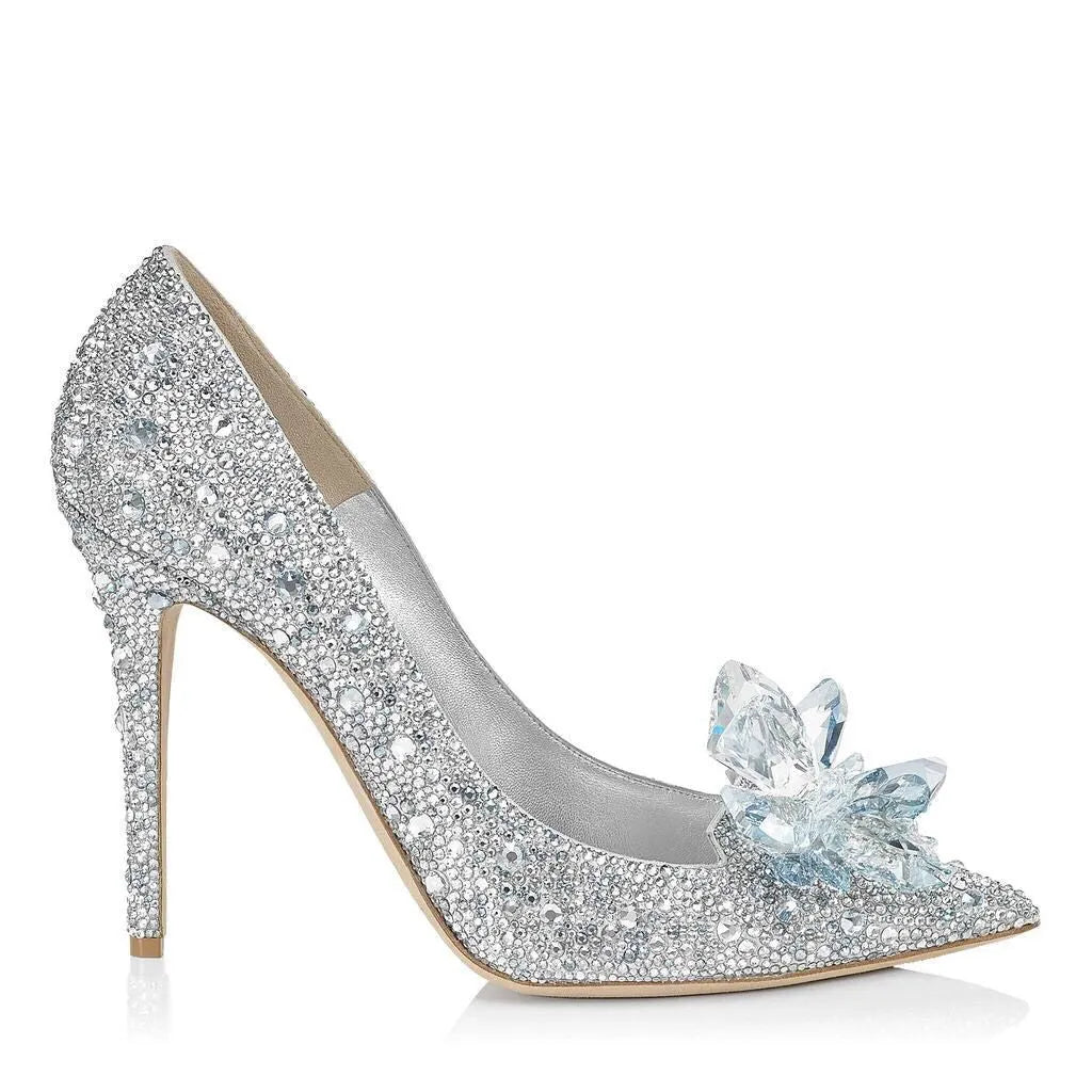 Women's gold pointed toe high heels with rhinestones and stiletto heel on a light background