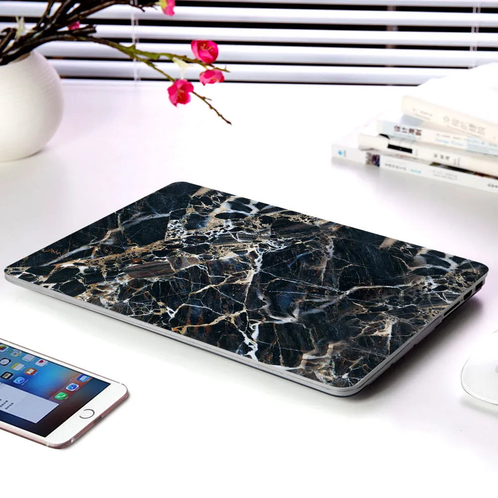 Plastic MacBook protective case in a marble pattern colour, shown next to a compatible Apple laptop.