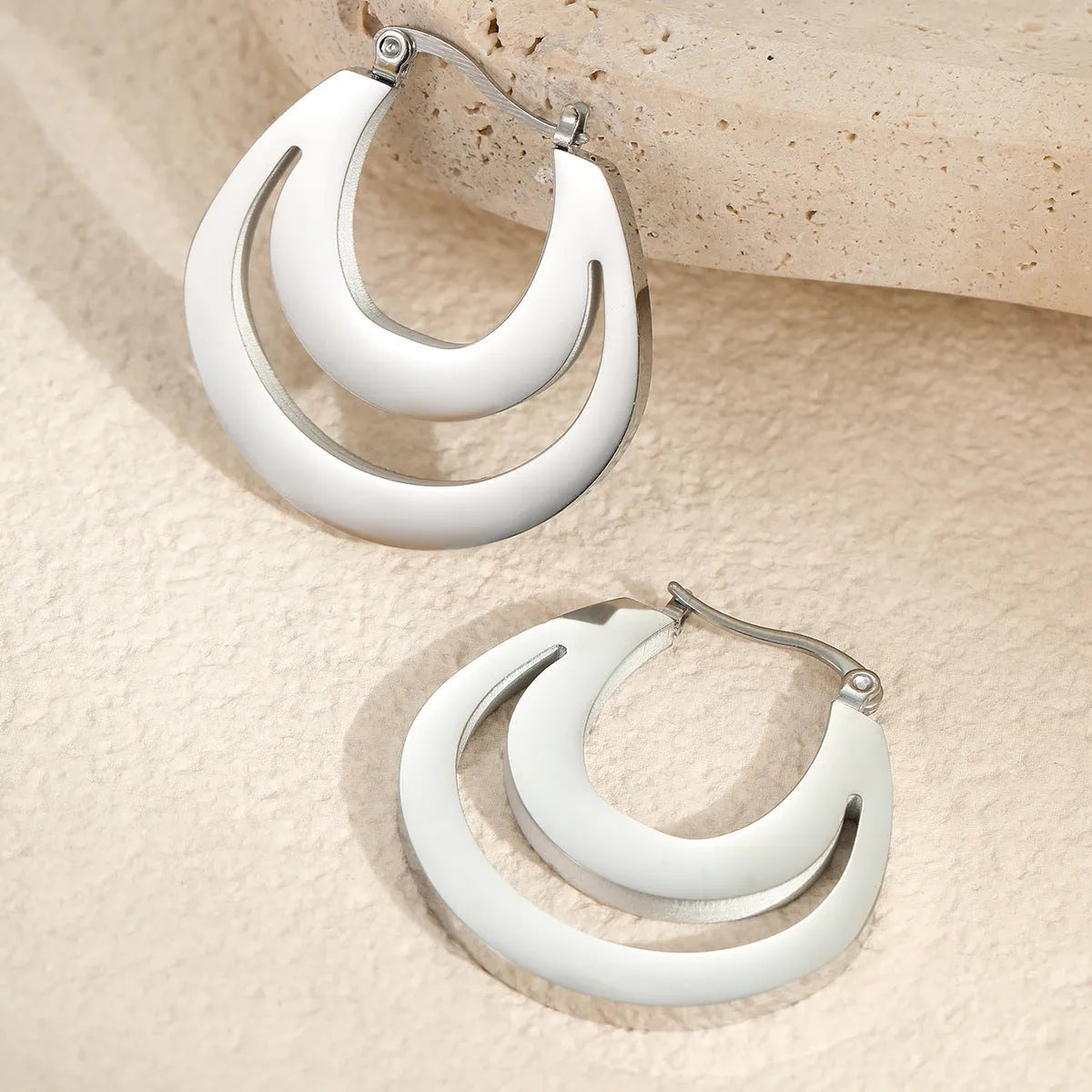 Geometric metallic French earrings in gold or steel colours with round ring design elements