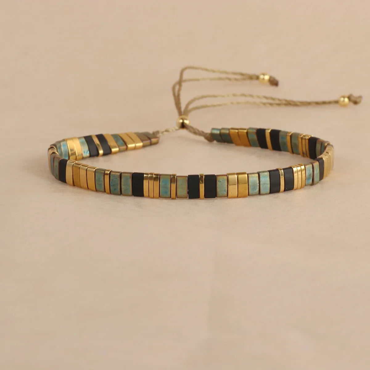 Adjustable pull beads glass bracelet in geometric shapes, shown in milky white colour.