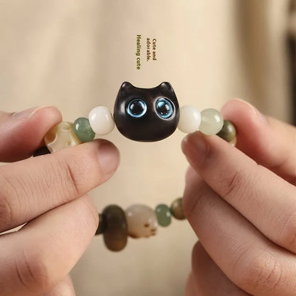 Hand-woven multi-treasure bracelet with jade, bodhi and ebony wood beads and a cartoon cat's paw charm.