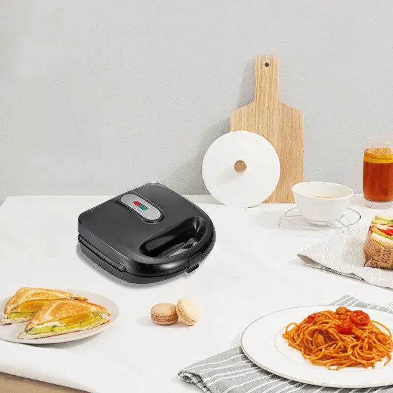Black double-sided heating electric sandwich pan with brushed stainless steel top cover and non-stick coating.